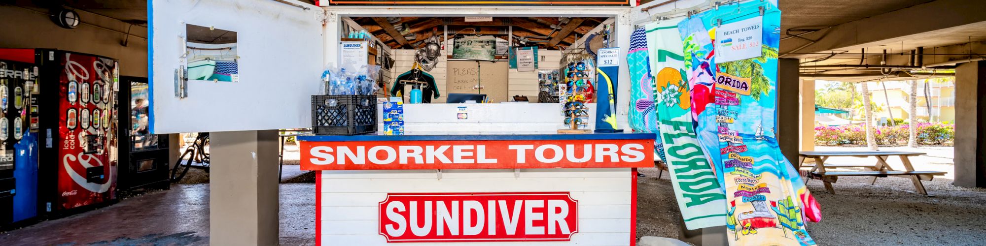 This image shows a ticket booth for snorkel tours under a building labeled with 